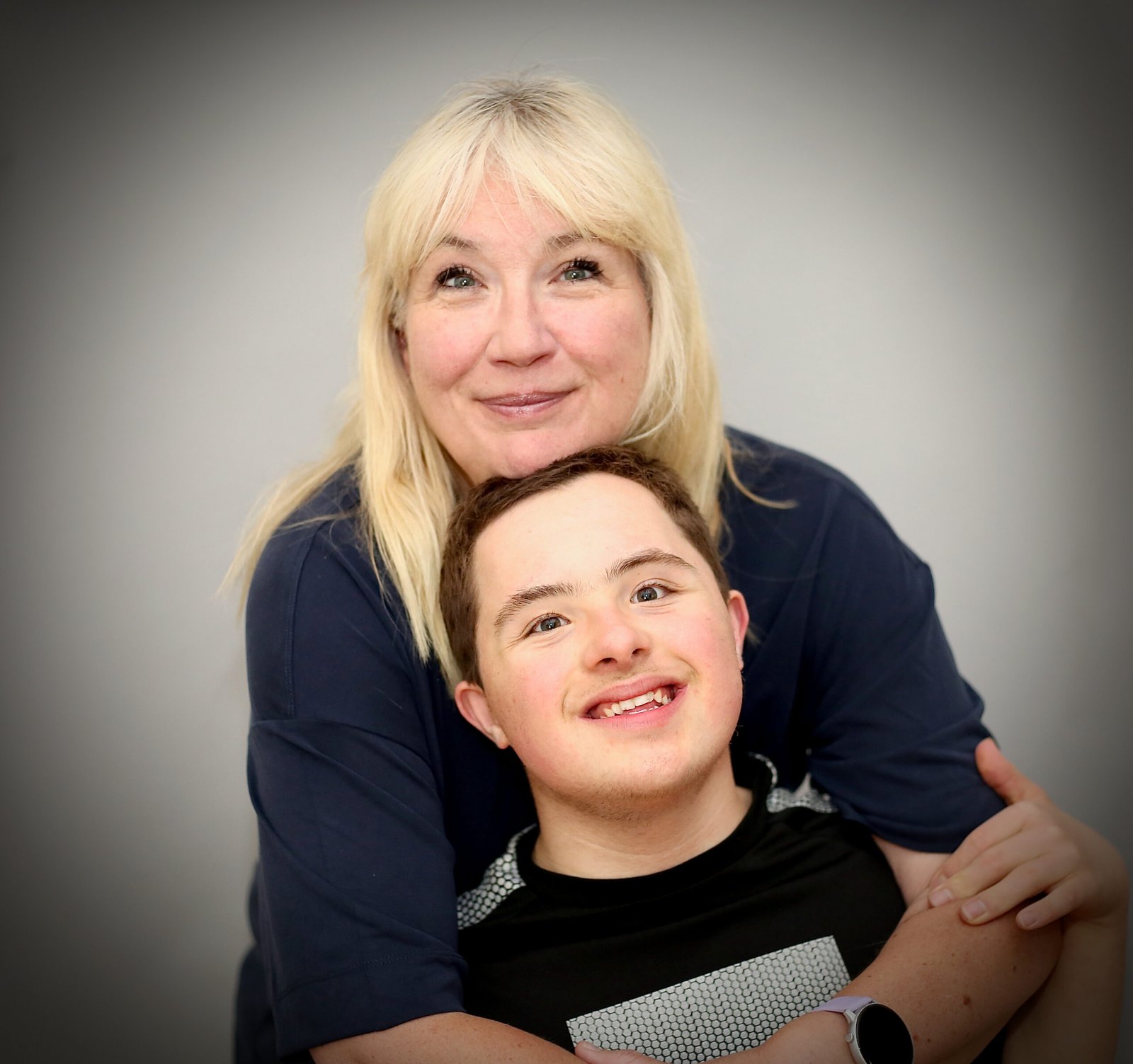 Woman cuddling teenage son