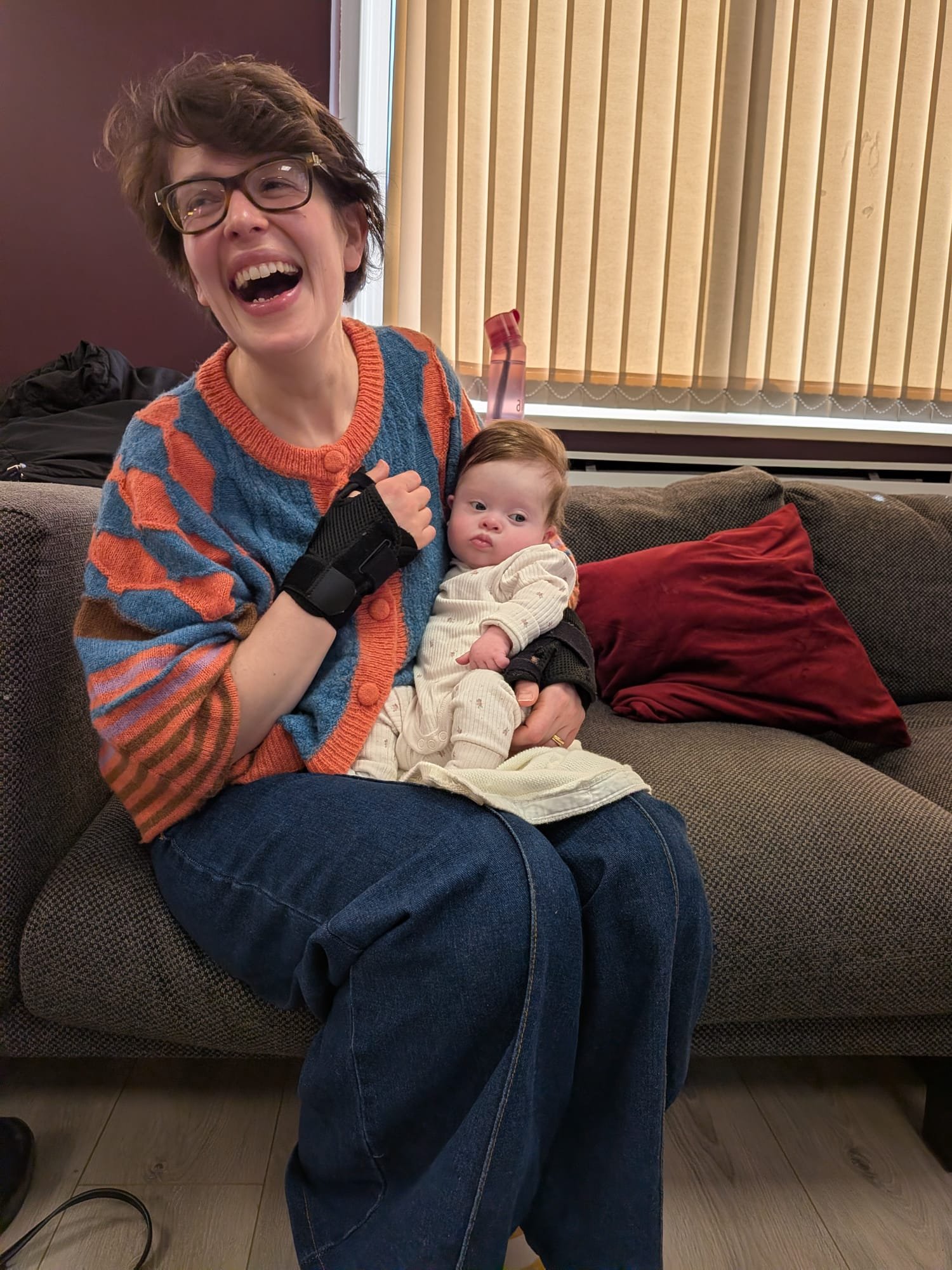 A mum laughing joyfully while cradling her newborn baby