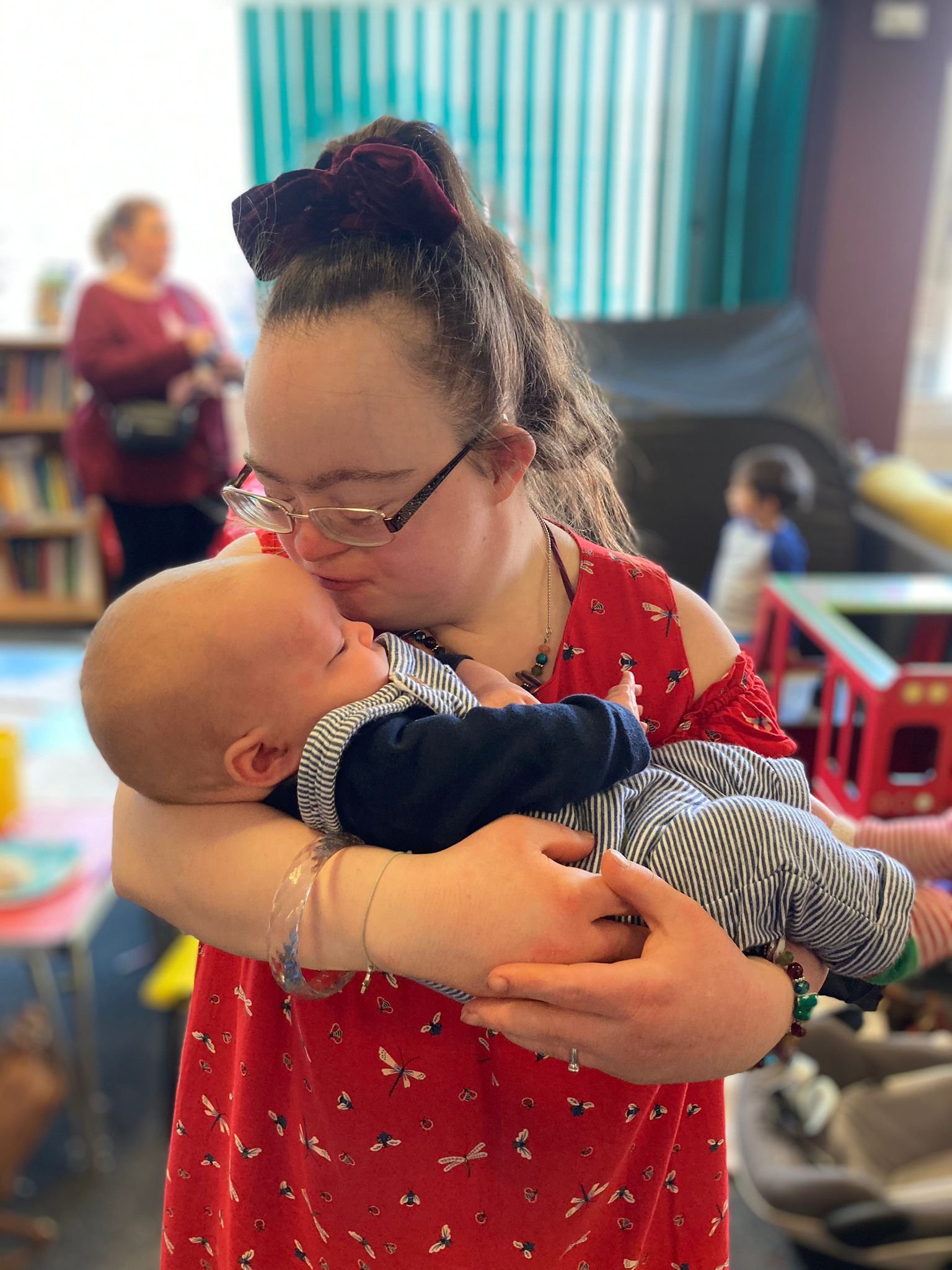 Adult lady with Down syndrome holding baby